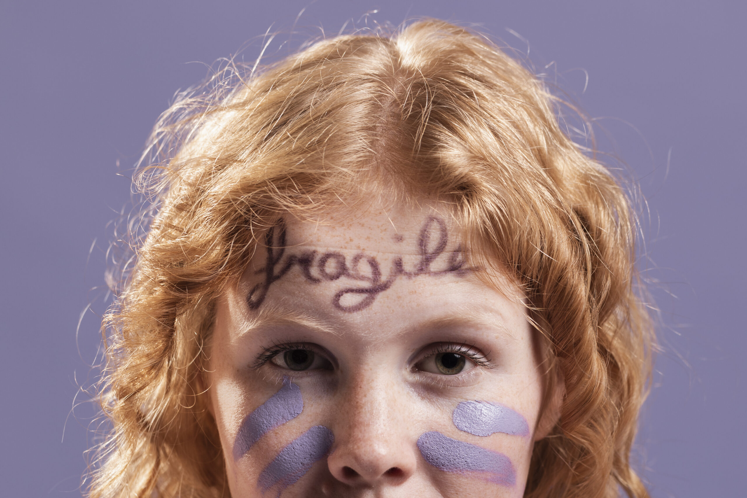 redhead-woman-posing-while-being-covered-with-dismissive-words-paint